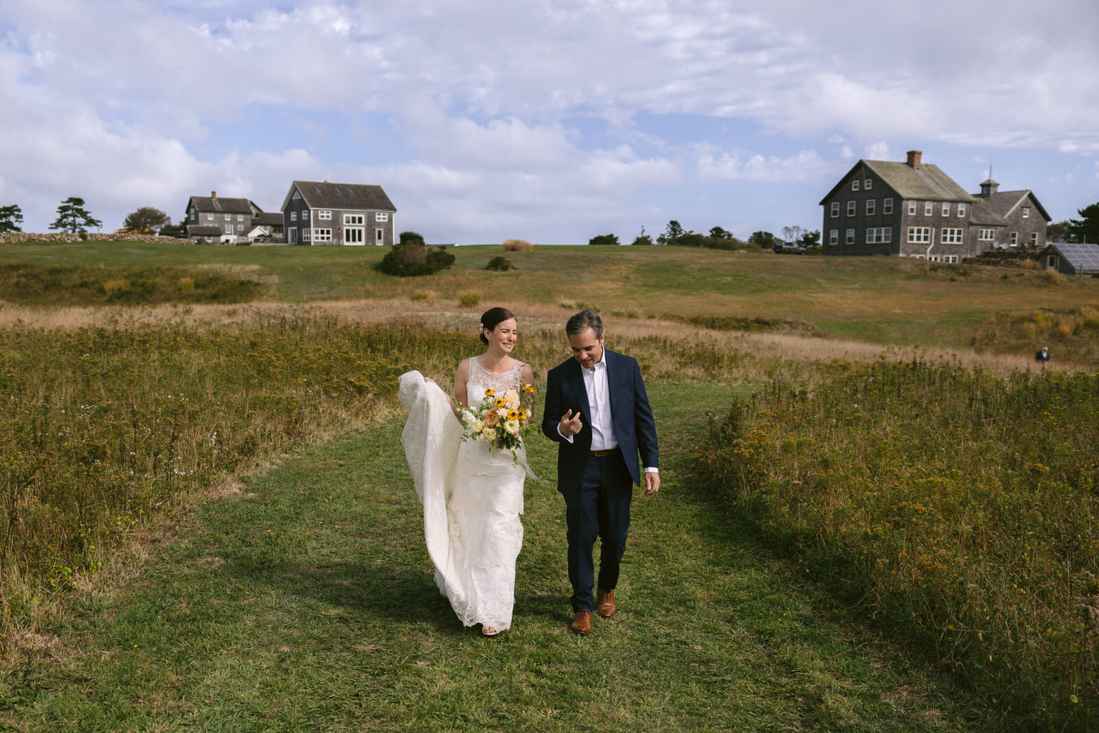 Sarah and Jason walking down to their farm ceremony on their wedding day on block Island